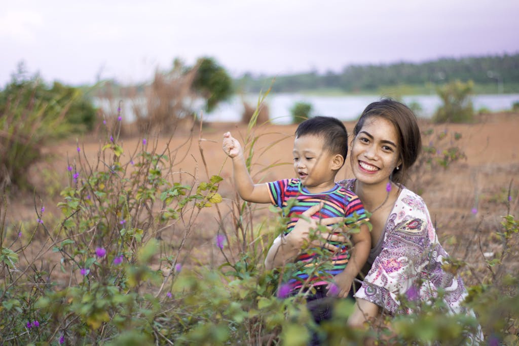 A happy mother and son enjoying a day outdoors in a picturesque countryside setting.