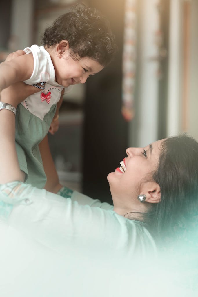 A joyful mother and child sharing a tender moment together indoors, radiating happiness.