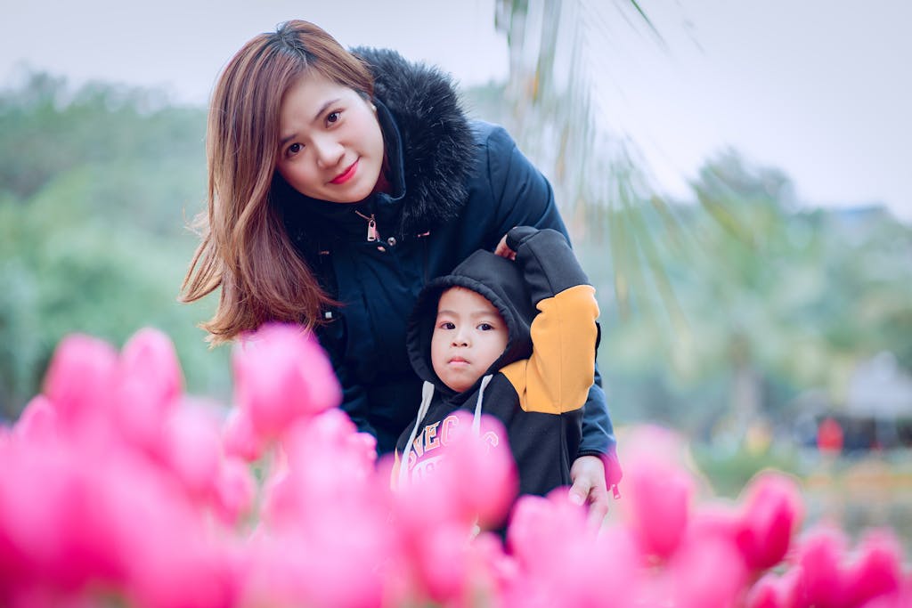 A mother and child enjoying a day in a vibrant tulip garden, capturing a joyful moment.