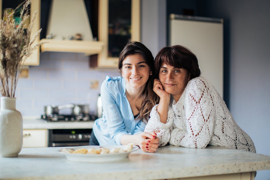 A mother and daughter bonding in the kitchen, smiling and enjoying their time together.